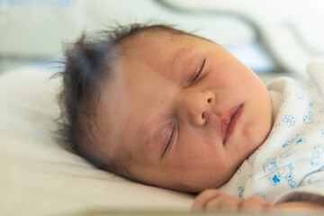 Newborn baby sleeping peacefully on soft bed sheet
