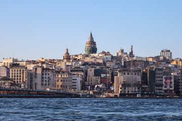 Naklejka premium Historic Galata Tower Rising Above the Istanbul Cityscape from the Water
