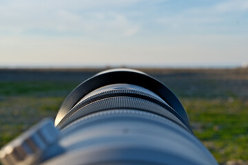 Photographer’s Lens. Camera Lens Aimed at the Horizon