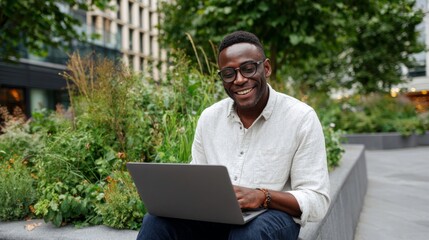 Man sitting outdoors using laptop