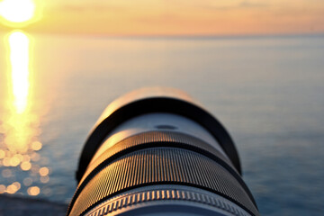 Photographer’s Lens on Pebble Beach at Sunset. Camera Lens Aimed at the Open Sea.