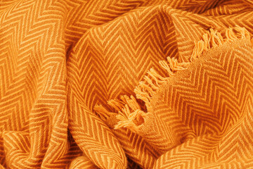 Close-up of mustard wool scarf with detailed herringbone weave and fringe