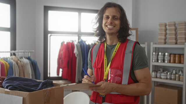 Man writing on clipboard in building volunteer center, holding pen and checking donations; duty community service.