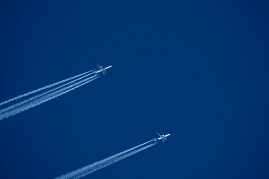 Airplanes in the blue sky. Contrails from two planes flying side by side