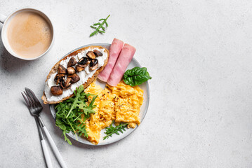 Healthy balanced breakfast with scrambled eggs, sandwich, ham