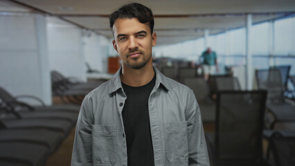 Young hispanic man stands confidently on a cruise ship deck, blending a casual outfit with the serene outdoor ambiance, exemplifying relaxed travel experiences.