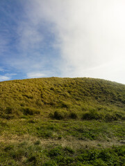 The view during a morning hike or sunrise on Mount Penanggungan is beautiful. It offers a vast landscape, including savannahs and ancient buildings like temples.