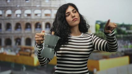 Woman holding a moka pot points finger toward a roman coliseum building while standing in front,...