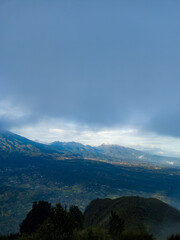 Obraz premium The view during a morning hike or sunrise on Mount Penanggungan is beautiful. It offers a vast landscape, including savannahs and ancient buildings like temples.