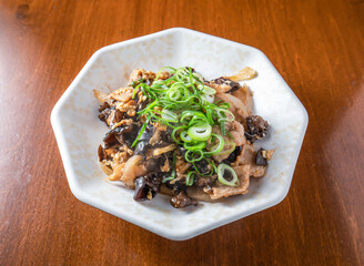 Experience the rich flavors of Moo Shu pork, expertly prepared with wood ear mushrooms and fresh scallions, served on a stylish plate. Perfect for food blogs.