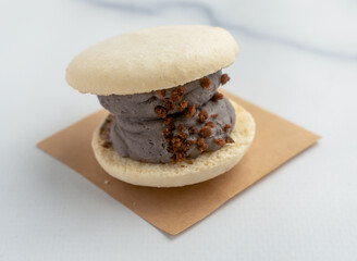 Indulge your senses with this charcoal macaron ice cream sandwich. The rich flavor is perfect for dessert menus or food blogs. Perfect for culinary creations.