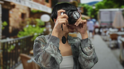 Young chinese woman with camera on a busy street capturing urban scenes in a vibrant outdoor city...
