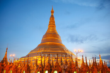 The main stupa of the Shwedagon Pagoda lit up at twilight in the evening. It is Yangon's most famous landmark and the most sacred Buddhist pagoda in country. The temple is in Yangon, Myanmar.