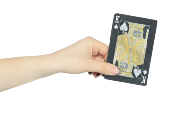 playing card king spades in hand, outstretched hand with black playing card isolated from background