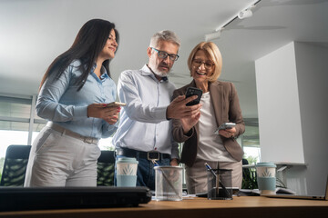 Diverse business people using smartphones in office