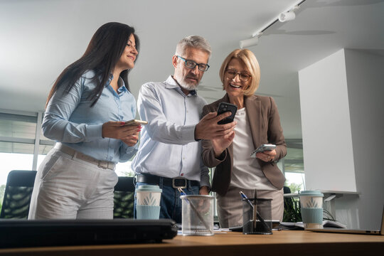 Diverse business people using smartphones in office