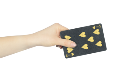 playing card hearts 7 in hand, outstretched hand with black playing card isolated from background