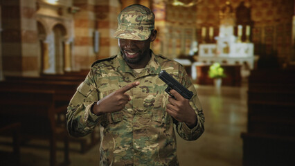Fototapeta premium Man soldier points finger at gun while smiling inside a church building, wearing camouflage uniform and cap; pride duty.