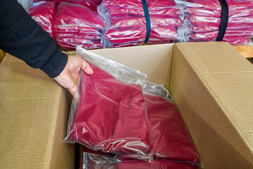 Textile industry. Packing of knitwear in cardboard boxes. Clothing warehouse.