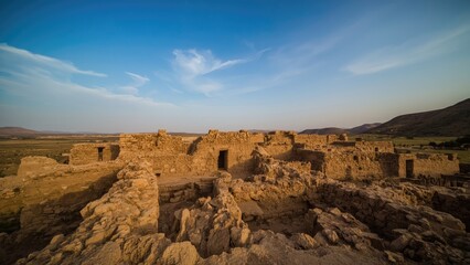 Ancient ruins at sunset with remaining stone structures and open sky. Archaeological site and history. The concept of historical preservation and archaeological exploration.