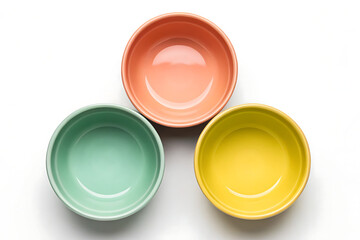 Empty pastel ceramic bowls in peach, mint green, and yellow colors