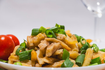 Fried potatoes with tomatoes and green onions, food photo for wallpapers and prints