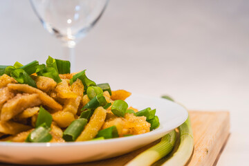 Fried potatoes with green onions on wooden board, food photo for wallpapers and prints