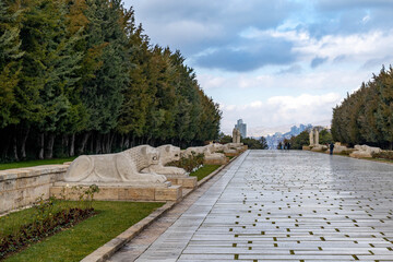 The Lion Road at Anıtkabir memorial complex, featuring granite lion statues in Hittite style lining the ceremonial avenue under trees. A majestic procession path in Ankara, Turkey.

