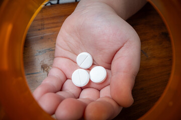 A powerful conceptual photograph showing a child's hand reaching for colorful, unattended...