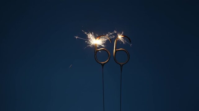 66 number made with sparklers in the form of sixty six on a dark background.