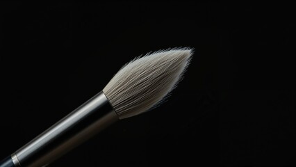 Close-up of a makeup brush with soft bristles against a black background.