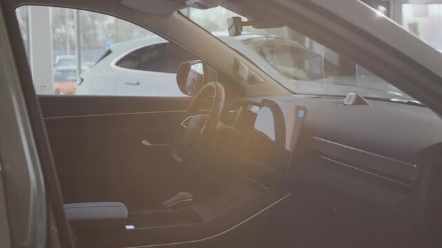 Pan right close up shot of modern car interior details shot through open door with focus on drivers seat and steering wheel, lens flare, copy space