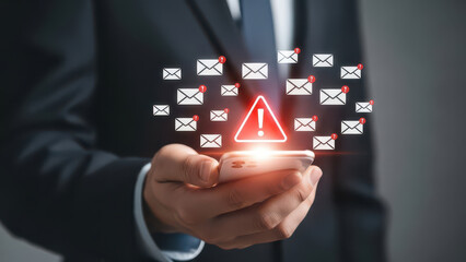 Person holding smartphone with many email notifications and warning symbol alert