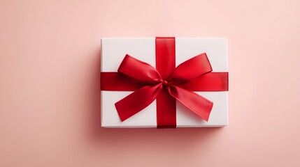 Elegant white gift box with a vibrant red ribbon perfect for birthdays anniversaries or holiday celebrations presented on a soft pink background