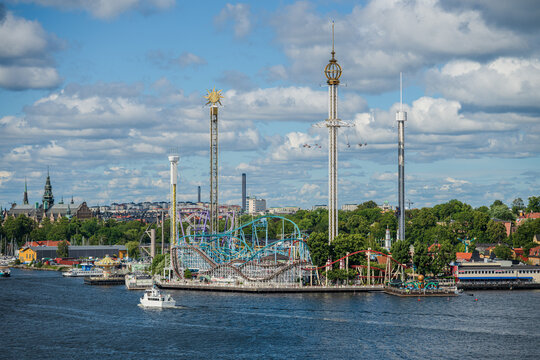 Stockholm, Sweden - August 04 2025: Colorful Skansen amusement park rides by waterfront.