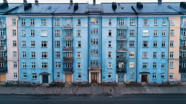 Symmetrical blue apartment building with balconies in urban setting