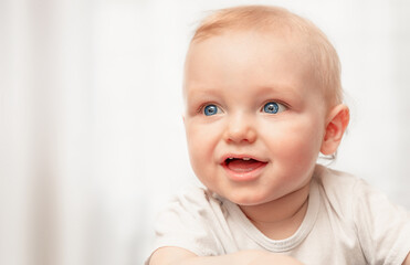 Portrait of a one-year-old baby smiling and looking away