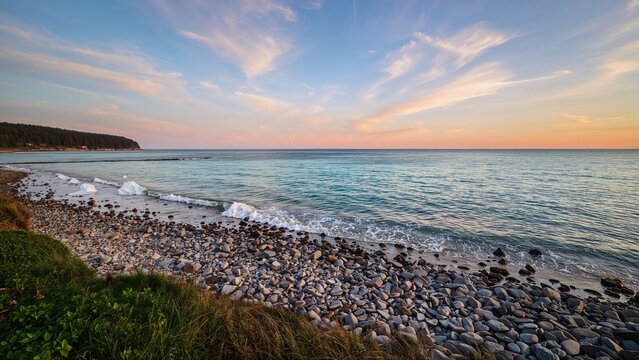 Peaceful beach scene with rocks, ocean, and colorful sky during sunset. Coastal landscape, nature view.