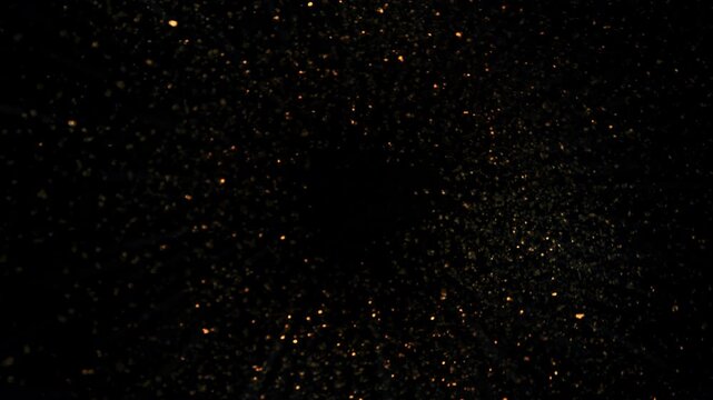Super Slow Motion Shot of Rotating Golden Glitters Towards Camera Isolated on Black 1000fps.