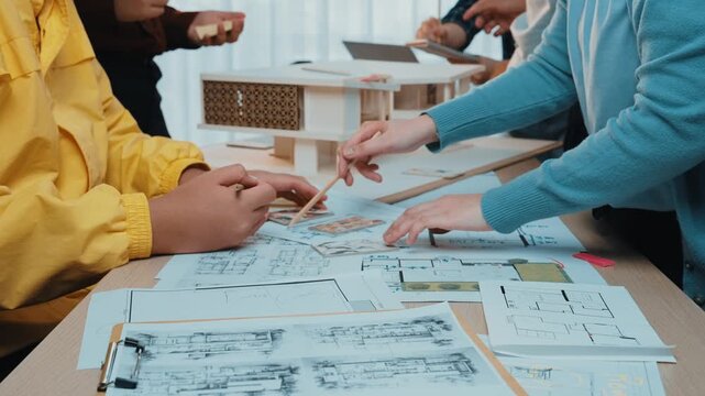 A dynamic workspace showcases a diverse group working on architectural models and blueprints, exchanging ideas, and engaging in collaborative design discussions. SACTR