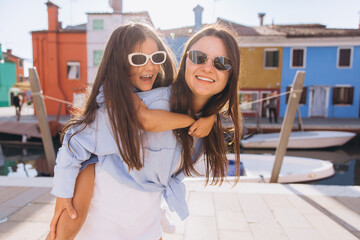 Mother and daughter enjoying piggyback ride in Burano