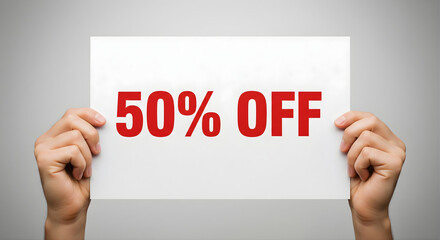 Hands holding 50 percent off sign concept of promotional discount sale for marketing offers and attracting customers to retail stores for limited time deals