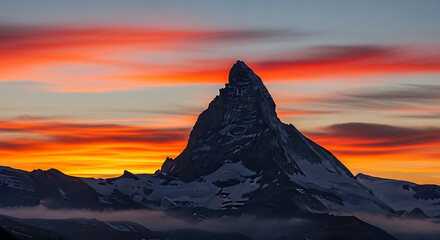 Majestic Mountain Peak Silhouetted Against a Fiery Sunset Sky summit mountain range