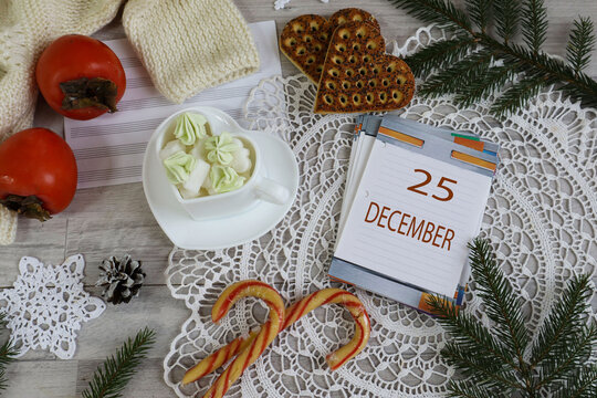 December 25th Calendar: The number 25 and the month's name in English on a decorative calendar surrounded by a lace napkin and Christmas sweets - Powered by Adobe