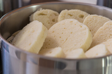 Detailed shot of a stainless steel pot filled with slices of traditional steamed dumpling