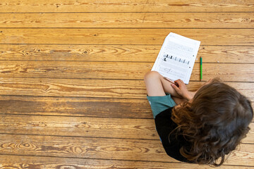 a child is sitting on the floor and do  homework for school