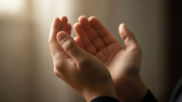 Close-up of gentle hands raised in dua, soft light illuminating the palms as a person quietly prays from the heart, expressing trust, gratitude and hope in the mercy of Allah

