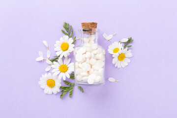 Fresh chamomiles with medicines on color background, top view