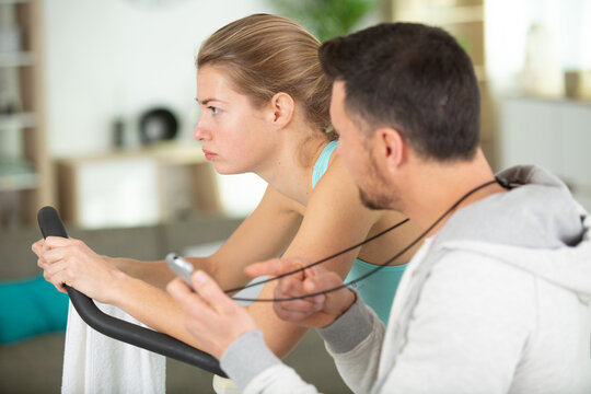 personal trainer encouraging a tired woman to continue exercising