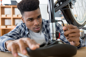 man securing bicycle seat with allen key